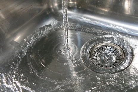 Wasser fließt in einen Abfluss